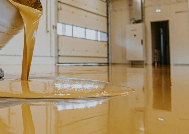Worker,,Coating,Floor,With,Self-leveling,Epoxy,Resin,In,Industrial,Workshop.